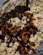 Load image into Gallery viewer, Pomegranate molasses being pored into a bowl of olives covered in ground walnuts
