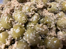 Load image into Gallery viewer, close up of green olives covered in coarsely ground walnuts
