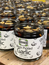Load image into Gallery viewer, side view of several rows or 16 ounce jars of pickled black garlic
